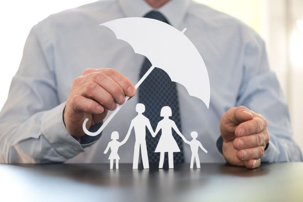 A man holds up paper cutouts representing life insurance for employees