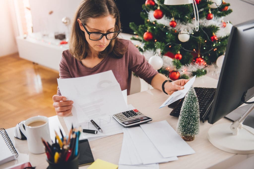 woman near christmas tree working on her finances 