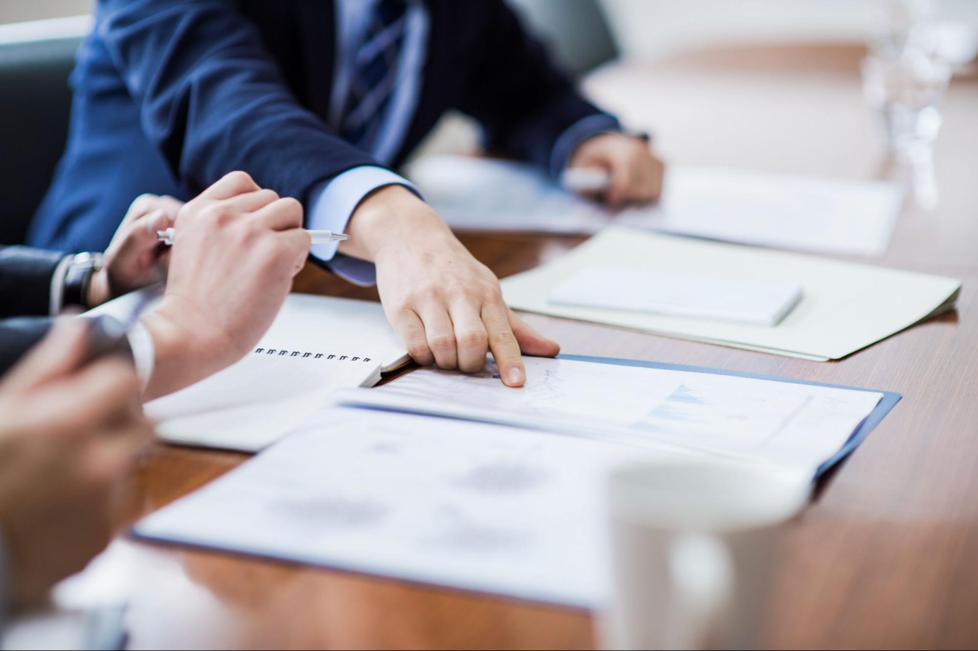 People in a business meeting share documents and discuss them.